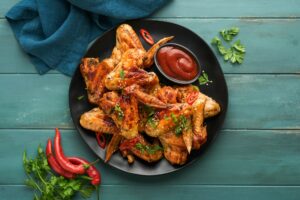 Chicken wings. Grilled or baked chicken wings with sesame seeds and ketchup or spicy tomato sauce on