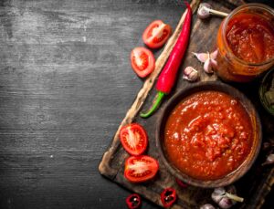 Tomato sauce with garlic and hot peppers on the Board.